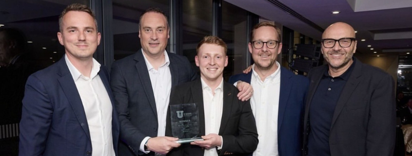 University of Leeds team standing together holding University of the Year award